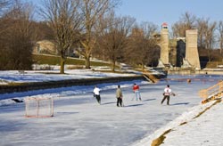 people playing ice hockey on the Trent Canal with the Peterborough Liftlock in the background