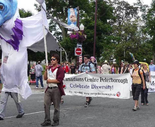 diversity parade, including people carrying a banner that says Canadians Centre Peterborough, Celebrate Diversity