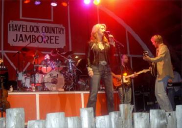 Female singer with male drummer, guitarist, and bassist performing at the Havelock Jamboree, a huge country music festival
