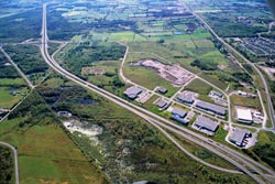 Aerial photo of Peterborough's industrial park at the south end of town, showing Highway 115 and the Otonabee River surrounded by green space