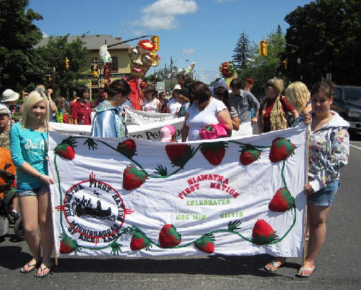 Girls holding a Kawartha First Nations and Hiawatha First Nations banner in preparation for a parade