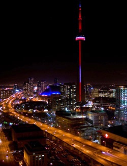 nighttime view of downtown Toronto with red-and-blue-illuminated CN Tower as focal point